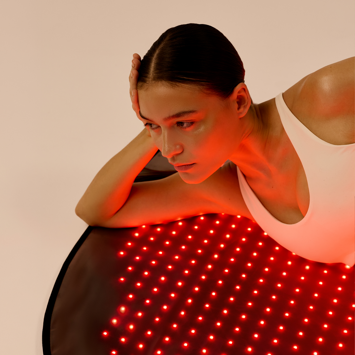 点灯した Restora LED マットで休み、両腕で上半身を支える女性
